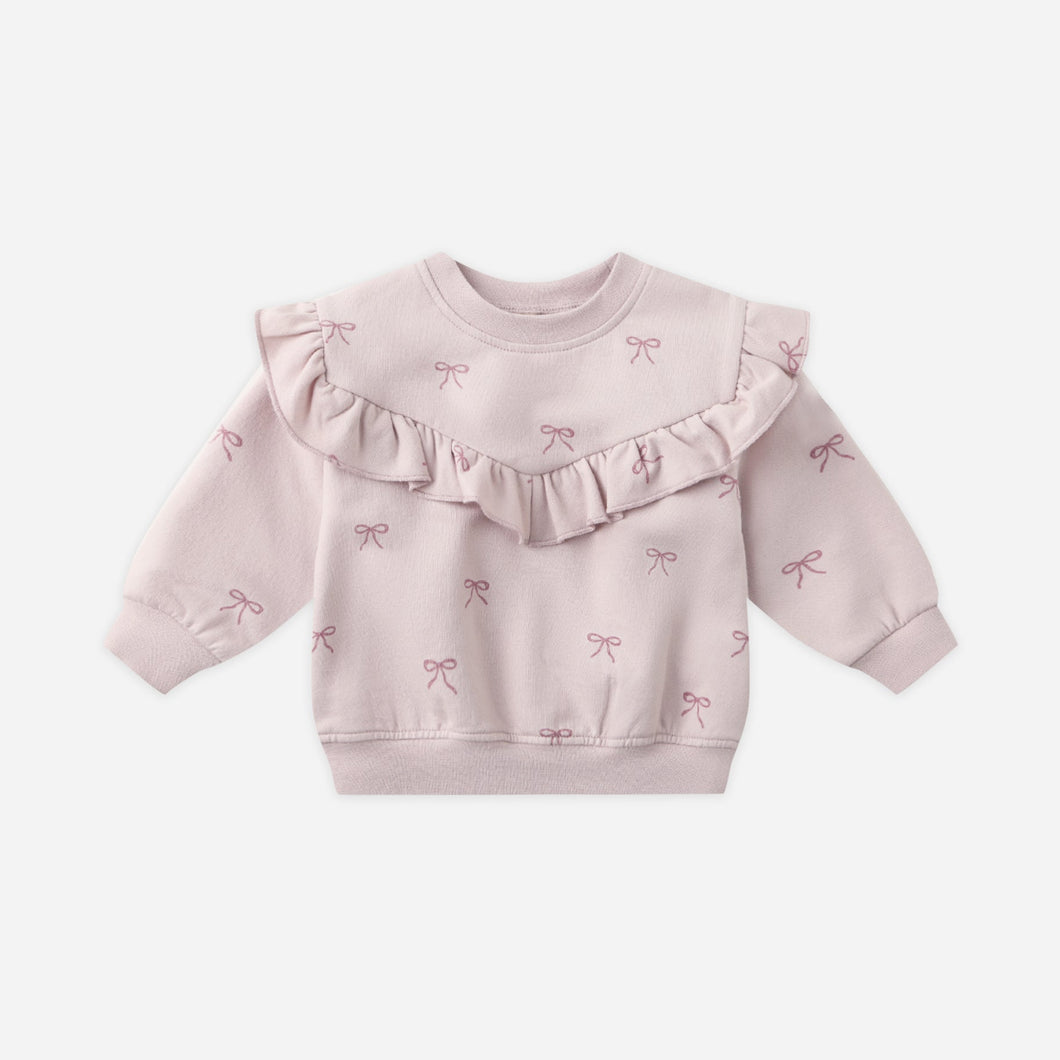 Pink baby sweater with ruffled details on a white background