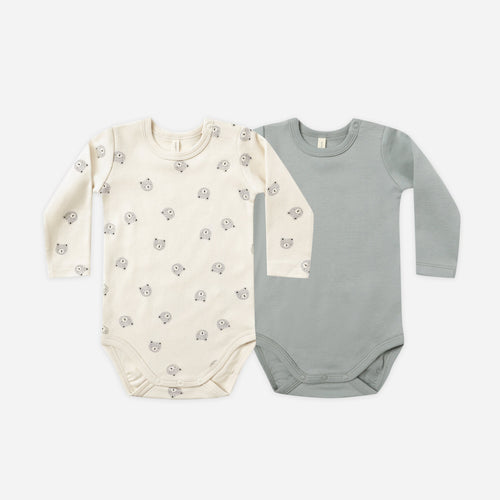 Two baby bodysuits, one cream with a pattern and one gray, on a white background.