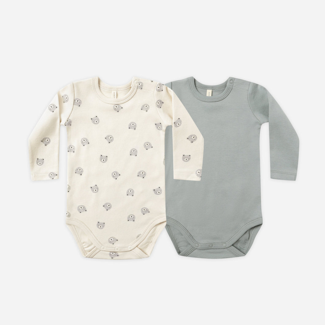 Two baby bodysuits, one cream with a pattern and one gray, on a white background.