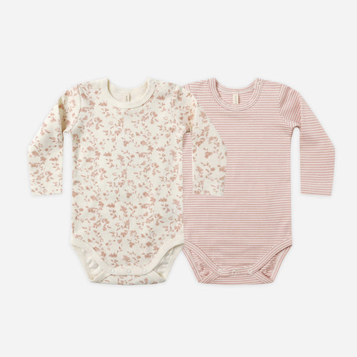 Two baby bodysuits, one floral and one striped, on a white background