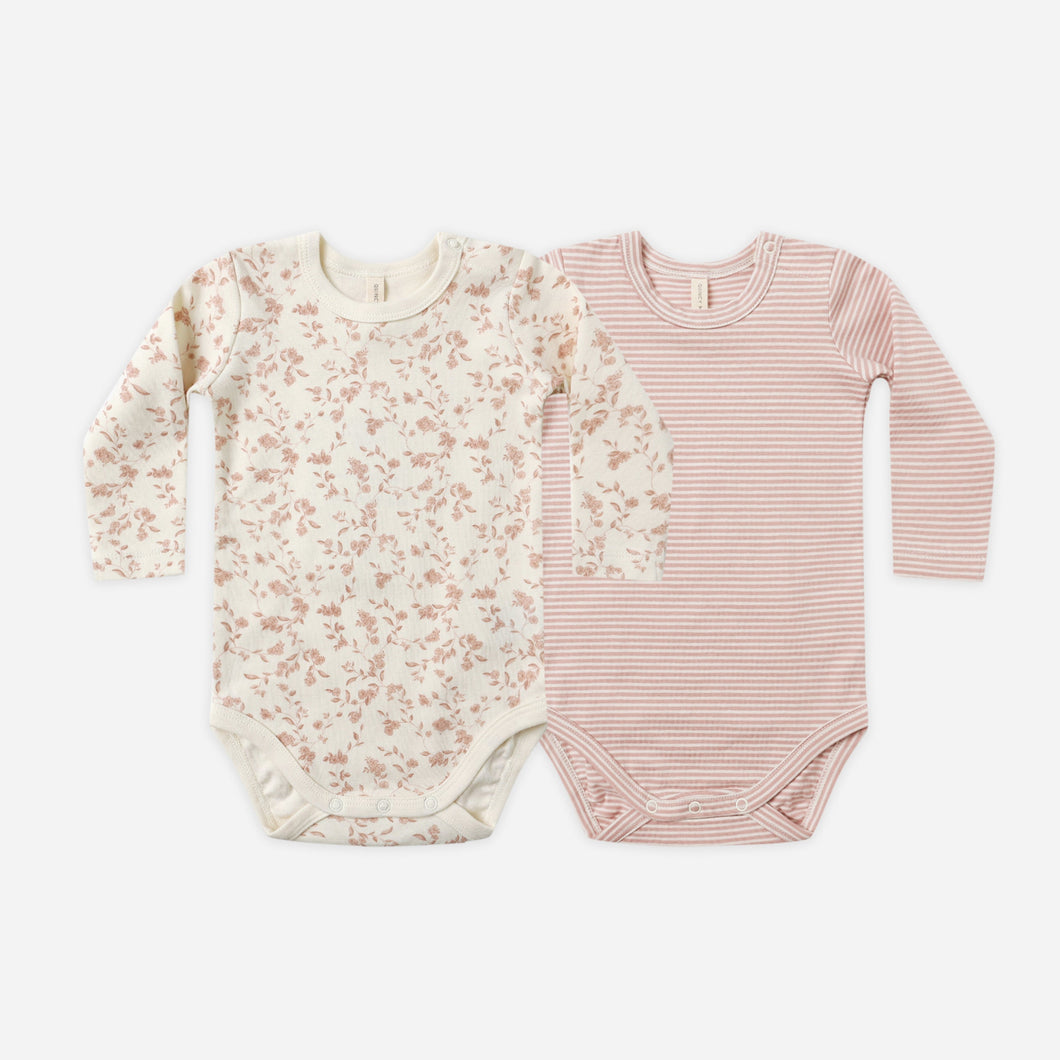 Two baby bodysuits, one floral and one striped, on a white background