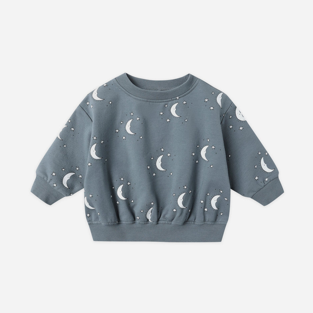 Blue children's sweatshirt with moon pattern on a light gray background