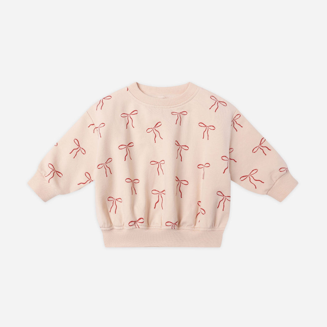 Pink sweatshirt with bow pattern on a white background