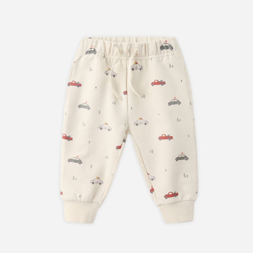 Beige baby pants with car pattern on a white background