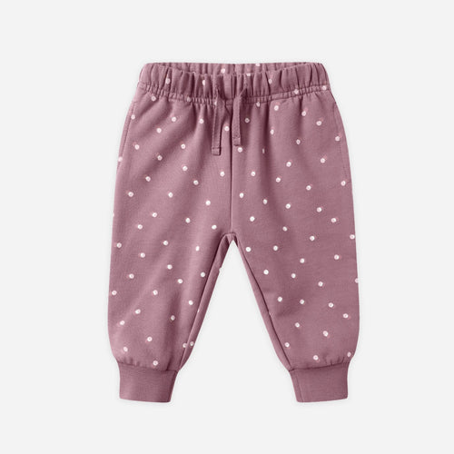Pink baby pants with white polka dots on a light gray background