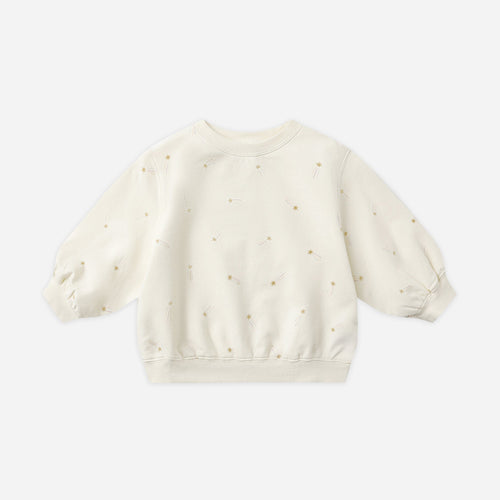 White baby sweater with small patterns on a light gray background