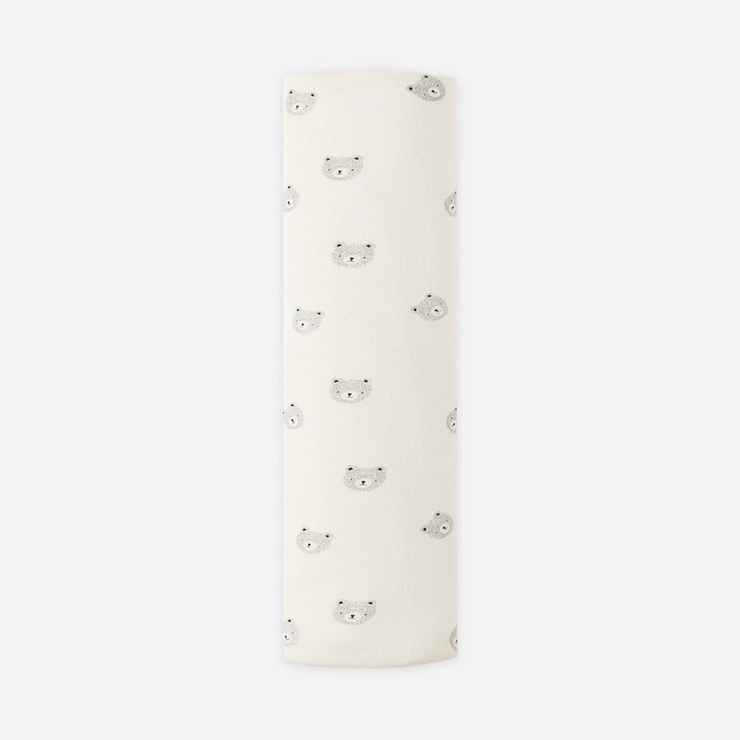 Roll of cream-colored fabric with butterfly pattern on a white background