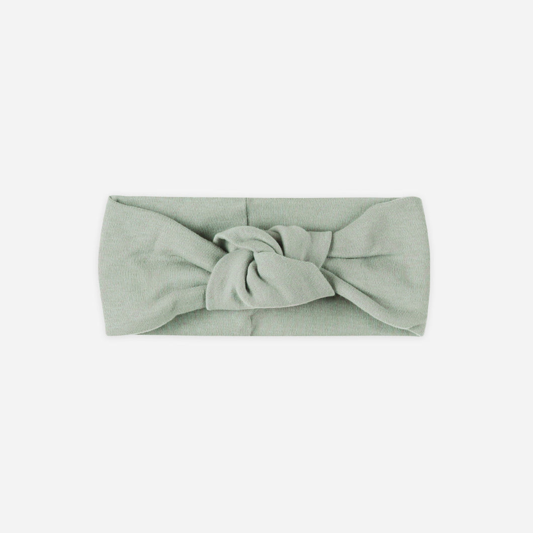 Green headband with a knot on a white background