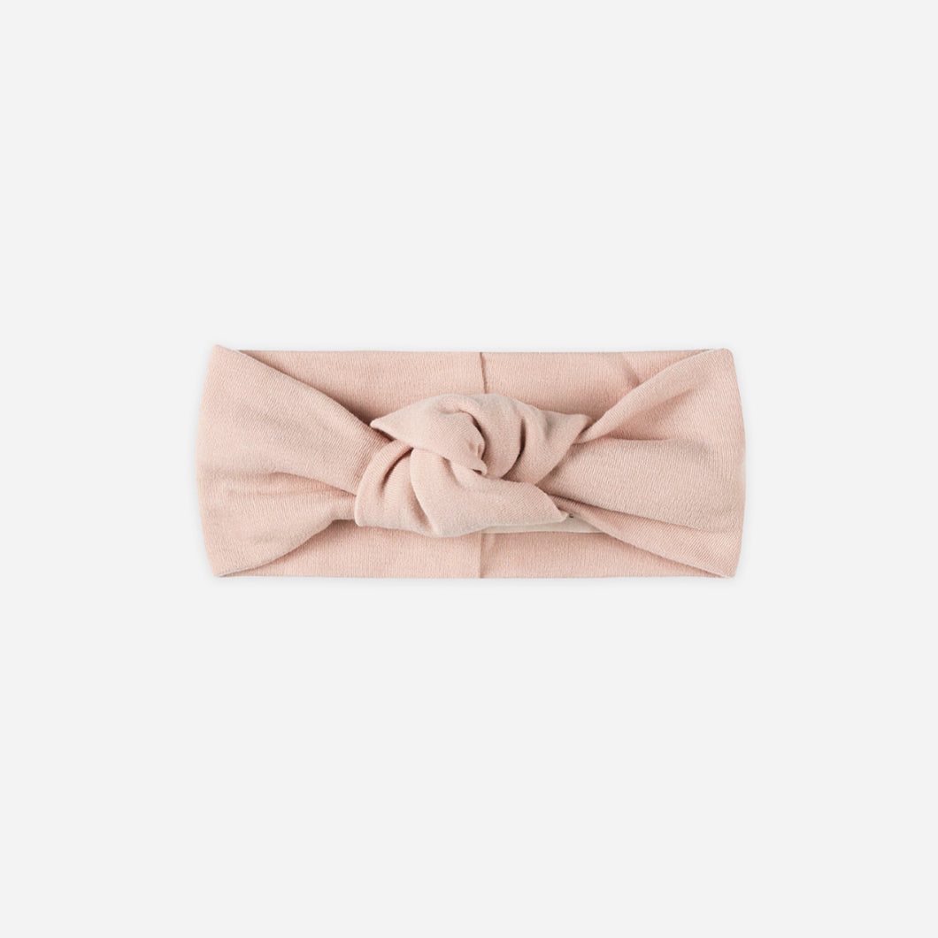 Blush pink headband with a knot on a white background