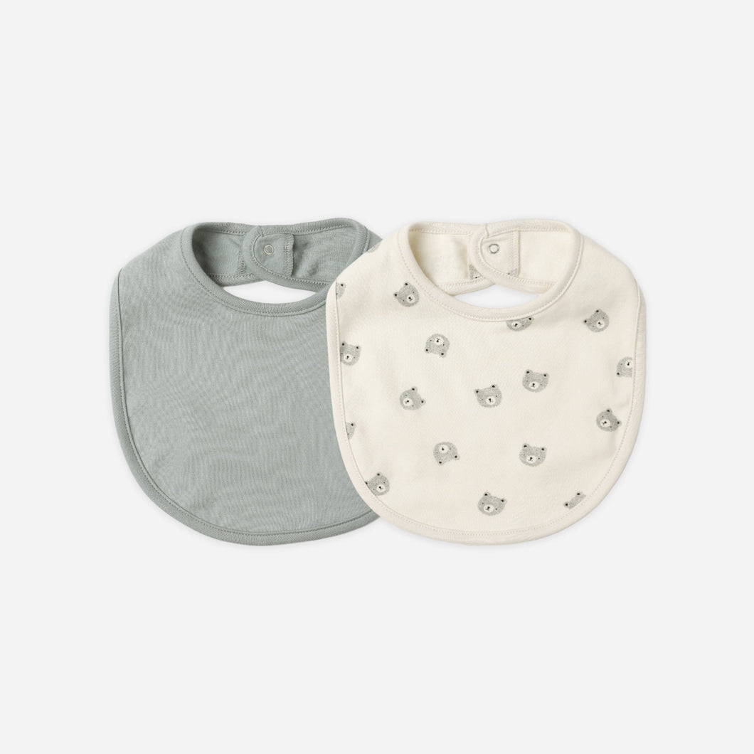 Two baby bibs, one gray and one white with a pattern, on a white background