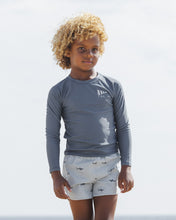 Load image into Gallery viewer, Baby and toddler navy long sleeve rashguard by Rylee+Cru, designed for swimwear, shown in a lifestyle setting with a child wearing it.