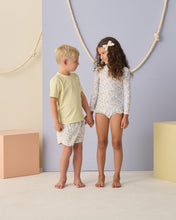 Load image into Gallery viewer, Baby girl wearing Rylee+Cru one-piece Rashguard Bloom swimwear with floral pattern, short sleeves, and full coverage for swimming.