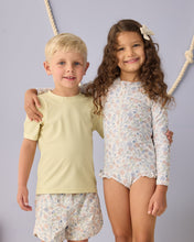 Load image into Gallery viewer, Baby girl wearing Rylee+Cru one-piece Rashguard Bloom swimwear, featuring bright floral pattern and long sleeves for sun protection.