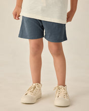 Load image into Gallery viewer, Baby boy in navy Sam Short swimwear by Rylee+Cru, featuring a comfortable fit and stylish design for toddlers.