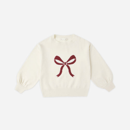 White sweater with a red bow design on a white background