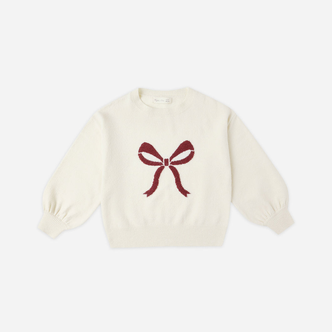 White sweater with a red bow design on a white background