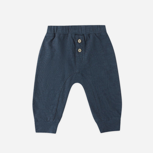 Navy blue baby pants with button details on a white background