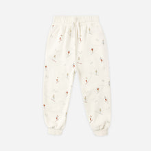 Load image into Gallery viewer, White baby onesie with small patterns on a light beige background