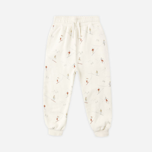 White baby onesie with small patterns on a light beige background