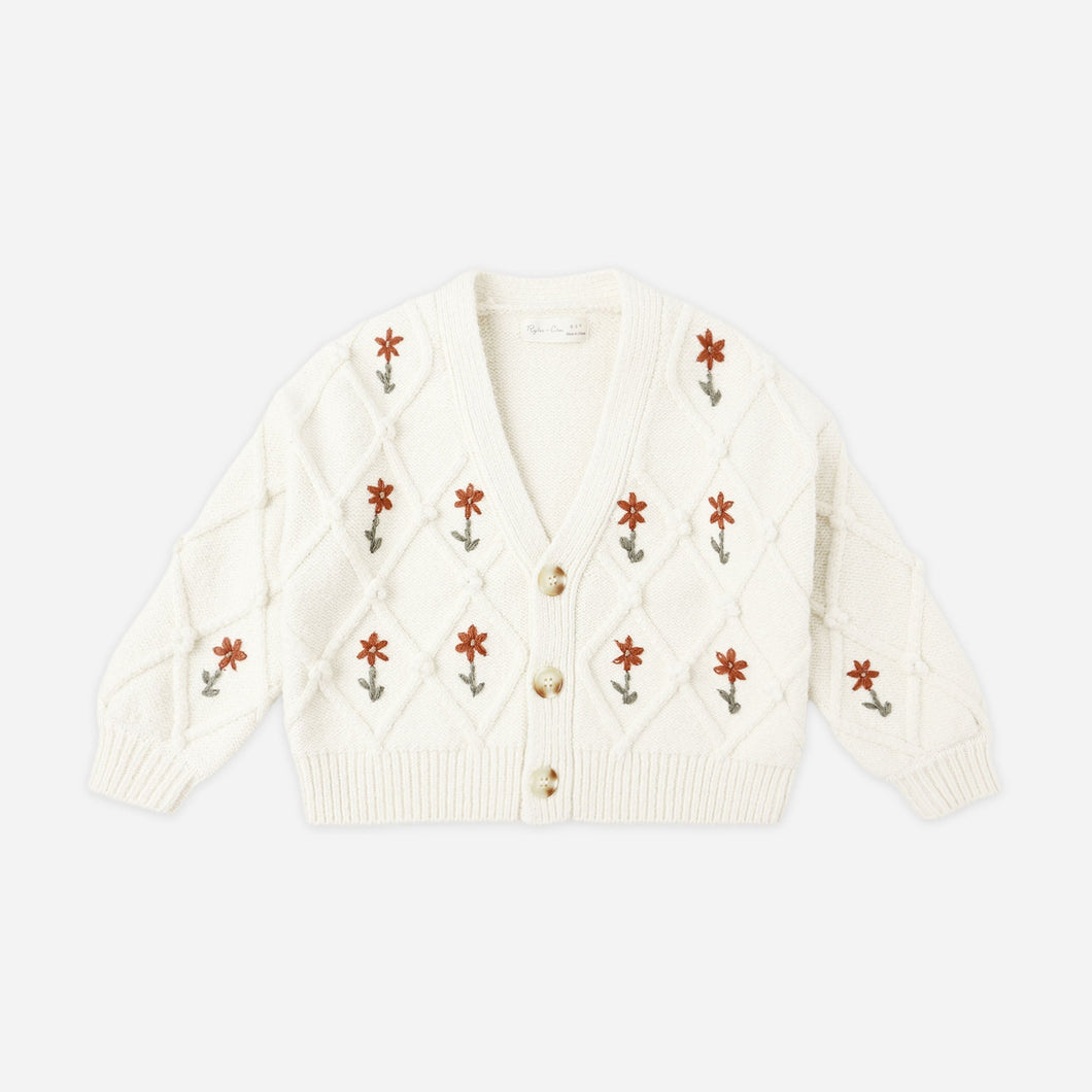 White cardigan with floral embroidery on a white background