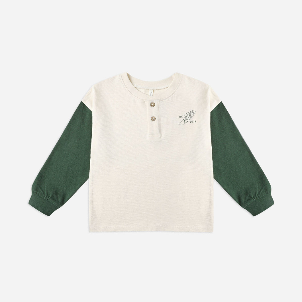 Long-sleeve shirt with green sleeves and a white body on a light beige background