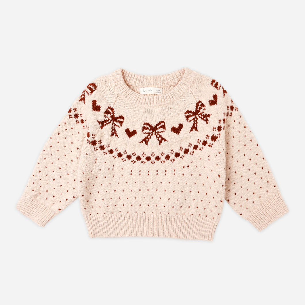 Pink sweater with bow pattern on a white background