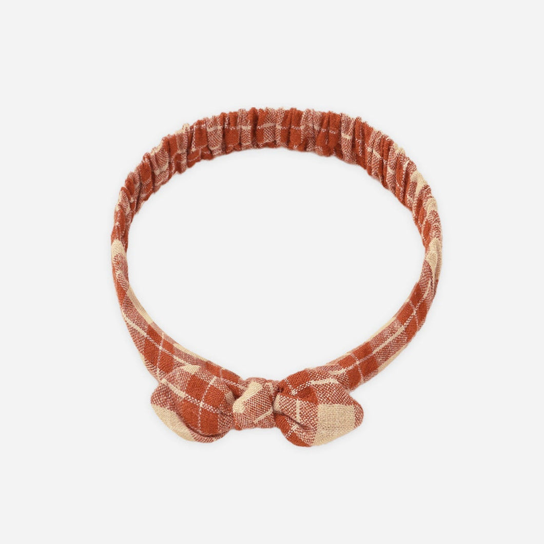 Rust-colored headband with a bow on a white background