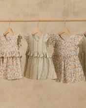 Load image into Gallery viewer, Blue floral Brielle dress by Rylee+Cru hanging on a rack, showcasing its vibrant pattern and lightweight fabric.