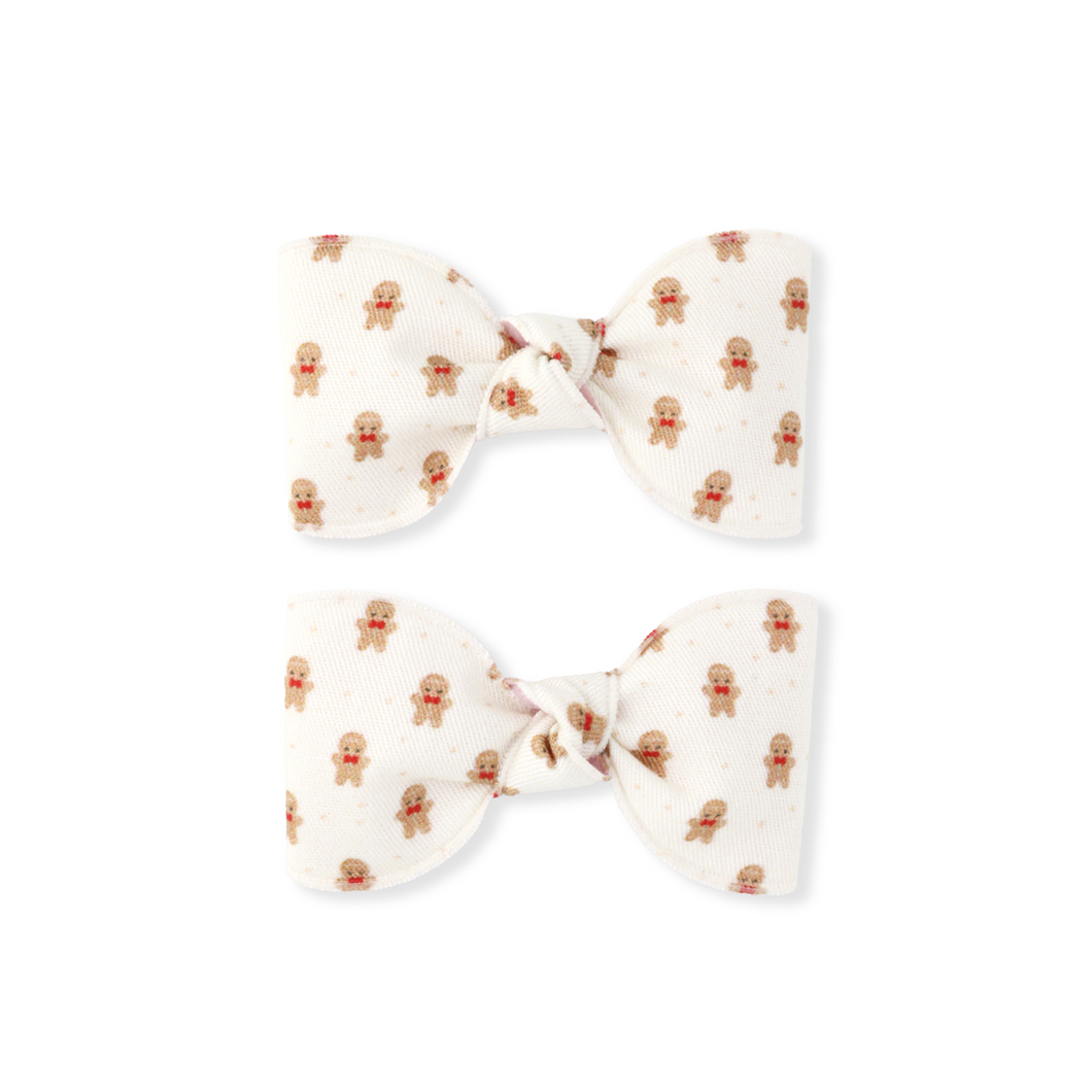 Two white hair bows with brown patterns on a white background