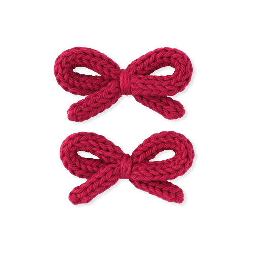 Two red knitted bows on a white background