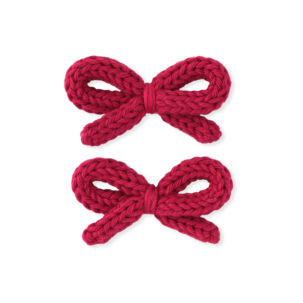 Two red knitted bows on a white background