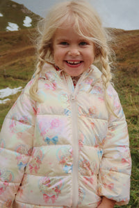 Young girl wearing a floral quilted jacket in a natural setting