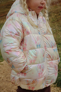 Child wearing a floral-patterned puffer jacket outdoors