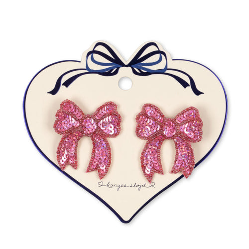 Heart-shaped card with pink sequin bow earrings on a white background