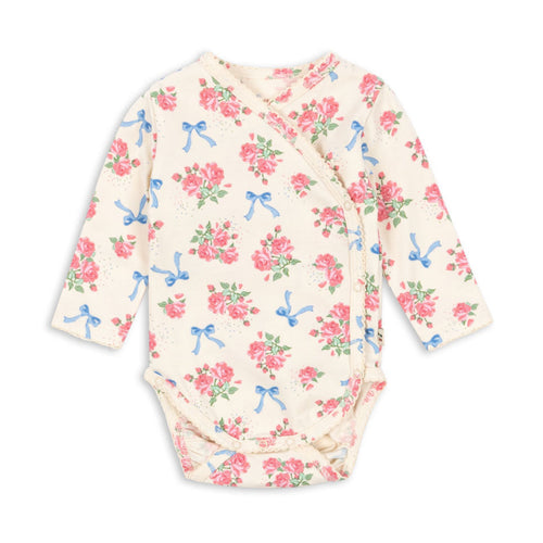 Floral-patterned baby bodysuit with bows on a white background