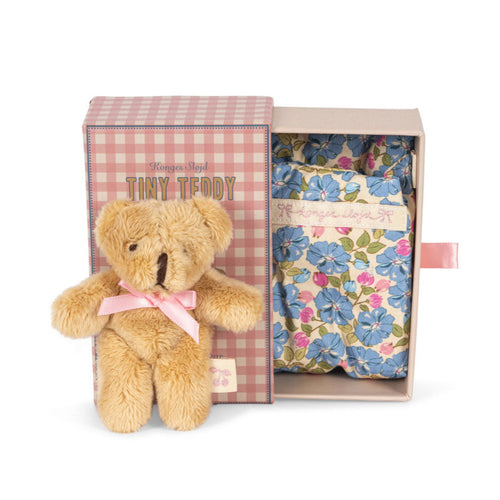 Small teddy bear with a pink bow in a gift box with a floral pattern on a white background