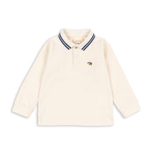Load image into Gallery viewer, Cream-colored long-sleeve shirt with a small logo on a white background
