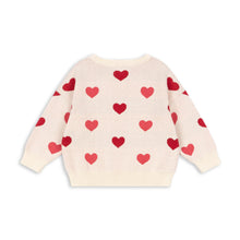Load image into Gallery viewer, Cream-colored sweater with red heart patterns on a white background
