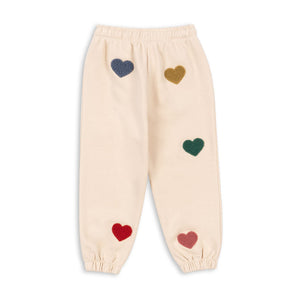 Beige pants with colorful heart patterns on a white background