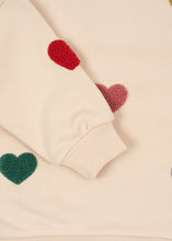 將圖片載入圖庫檢視器 Close-up of a beige sweater with red and green heart patterns.