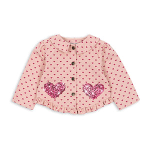 Pink polka dot blouse with heart designs on a white background