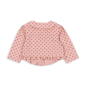 Pink polka dot blouse on a white background