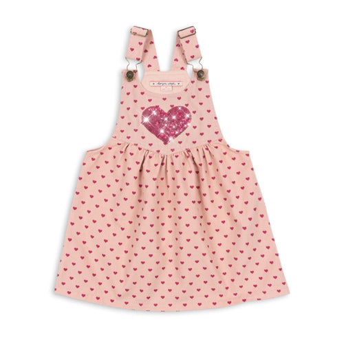 Pink polka dot pinafore dress with a heart design on a white background