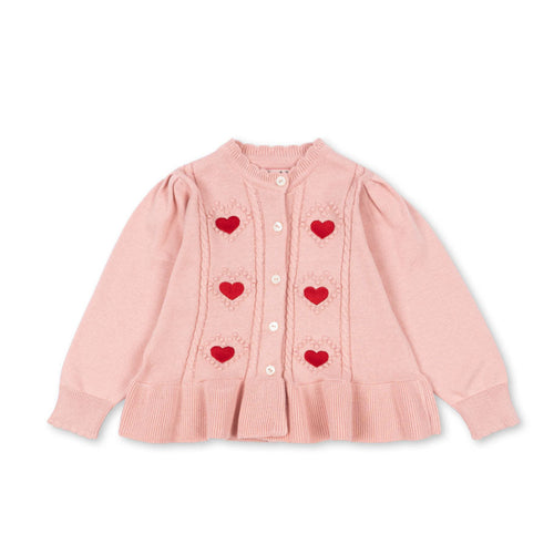 Pink cardigan with heart patterns on a white background