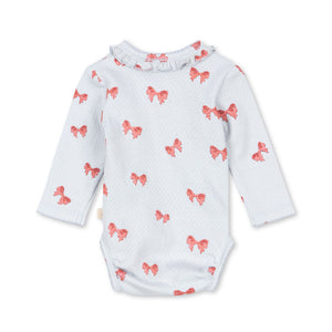 White baby onesie with red bow pattern on a white background