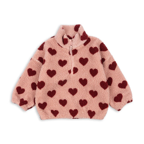 Pink fleece jacket with red heart patterns on a white background