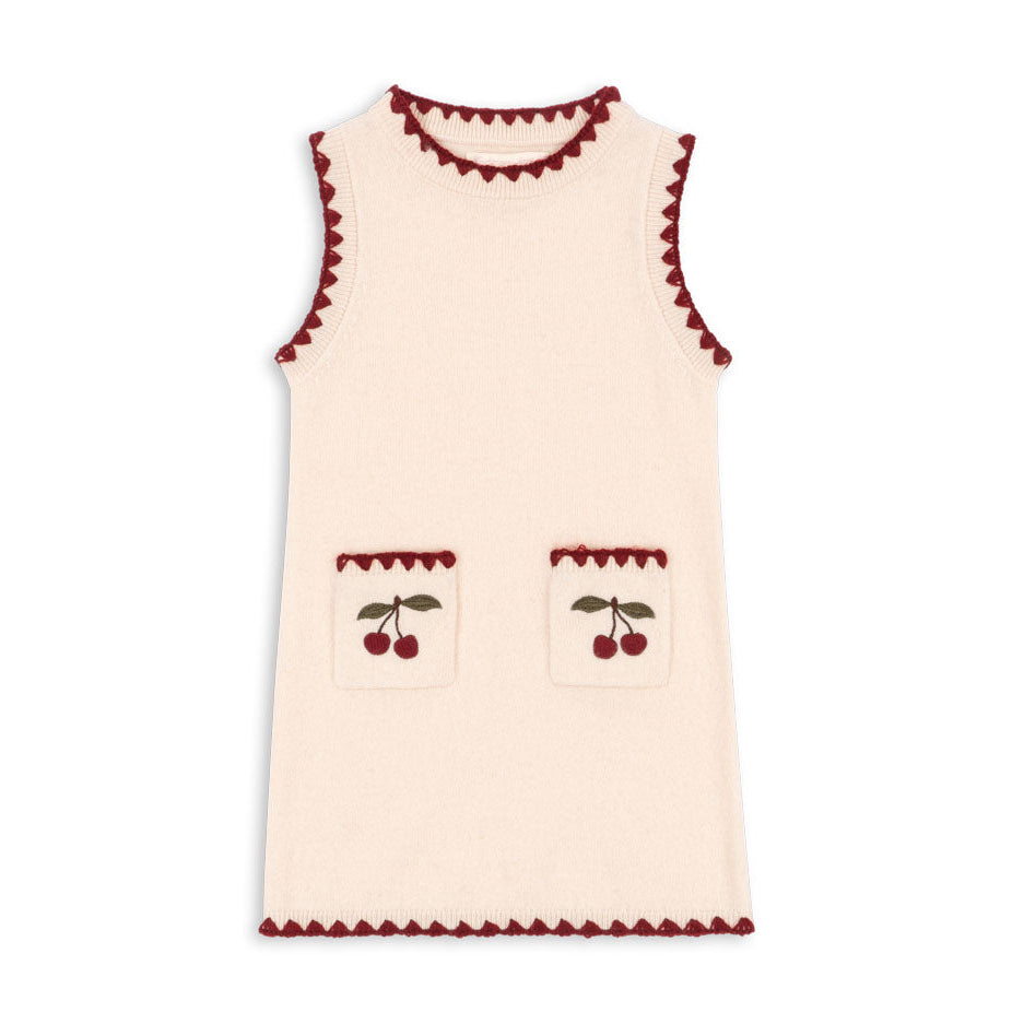 Cream-colored sleeveless top with red trim and cherry designs on a white background