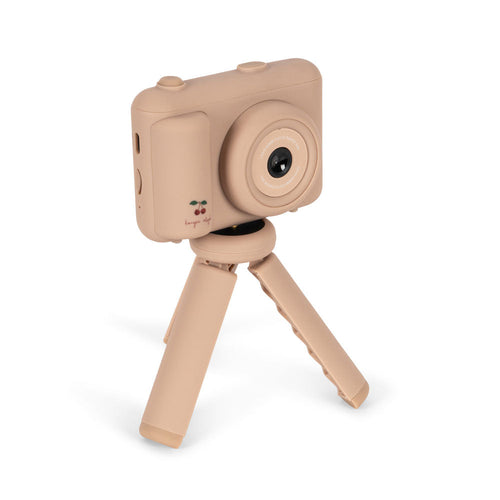 Beige toy camera with a tripod on a white background