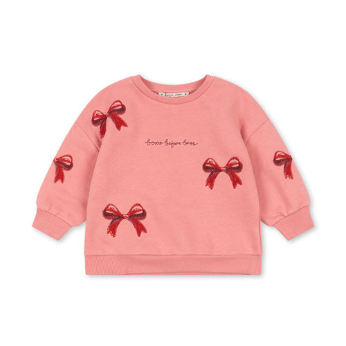 Pink sweatshirt with red bow designs on a white background