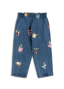 Blue jeans with floral embellishments on a white background